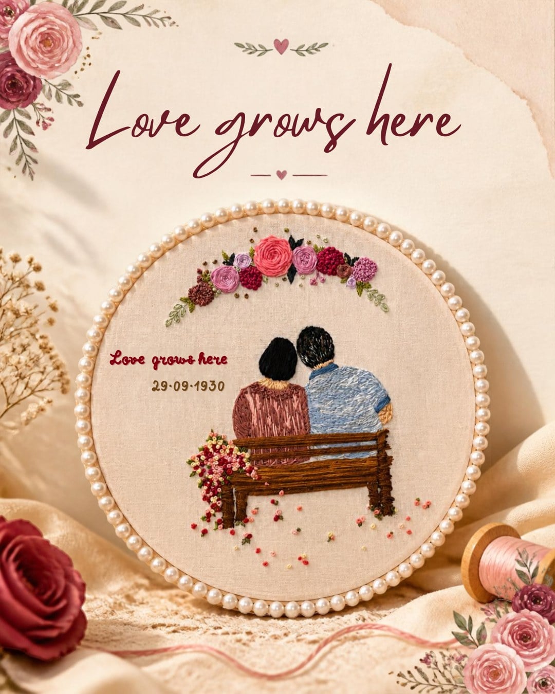Hand-embroidered hoop of a couple on a bench under roses, framed with pearls